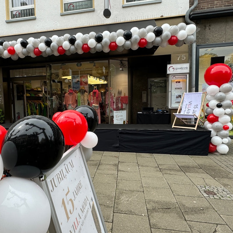 Ballondekoration als Girlande für das Jubiläum eines Modegeschäftes in der Viersener Innenstadt in schwarz, weiß, rot und grau