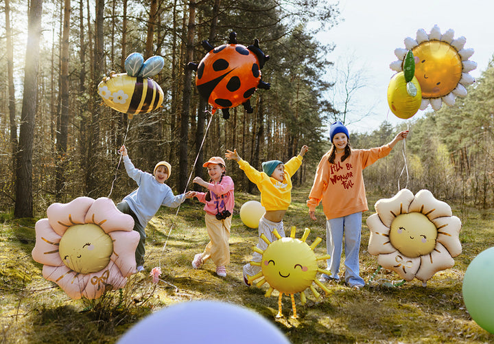 Gartenparty im Wald mit Sonnen- und Blumen-Folienballons als Kindergeburtstag-Deko